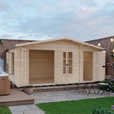 Shire Bourne 16x10 garden log cabin installed on a patio decking next to a hot tub.