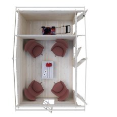 Top-down interior floor plan showing four armchairs around a coffee table and garden equipment stored in the side room.