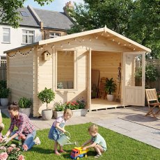 Family playing on garden patio in front of Shire Berryfield 13x10 log cabin with open doors