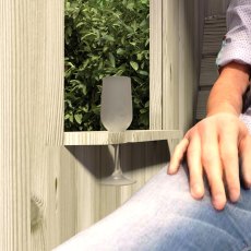 Close-up detail showing a person sitting on the Shire Fernook arbour bench with a drink on the side armrest table.
