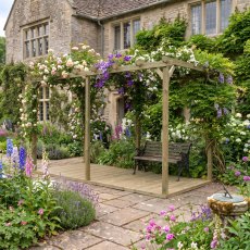 Shire 16x8 natural wooden garden pergola with integrated decking base and climbing plants in a residential garden