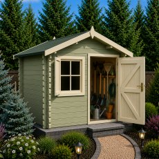 Exterior view of the compact, light-green Shire Belham log cabin with an open single door showing stored garden tools inside, set on a gravel path against a backdrop of pine trees.
