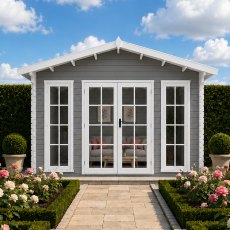 Exterior front view of a grey-painted Shire Epping log cabin with white-trimmed double glass doors, full-length side windows, and potted flowers framing a stone pathway entrance under a blue sky.