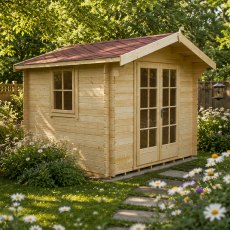 Exterior view of the natural timber Shire Dalby log cabin featuring double glazed doors, a side window, and a red felt apex roof, situated in a garden surrounded by white flowers and a stone stepping-stone path.