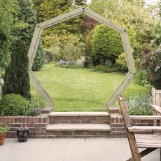 Grange Hex Moon Gate Wooden Garden Arch - insitu next to a garden wall